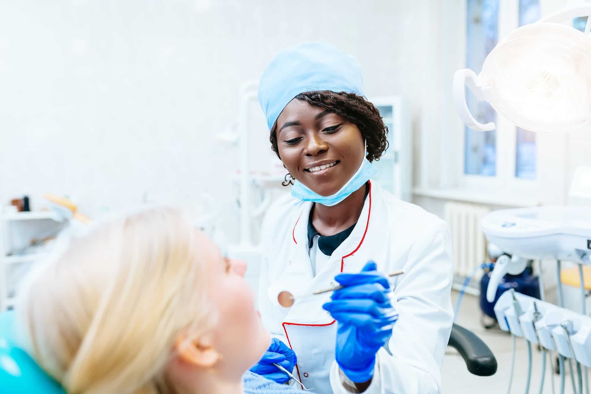 African american female dentist treating patient at clinic. Dental clinic concept