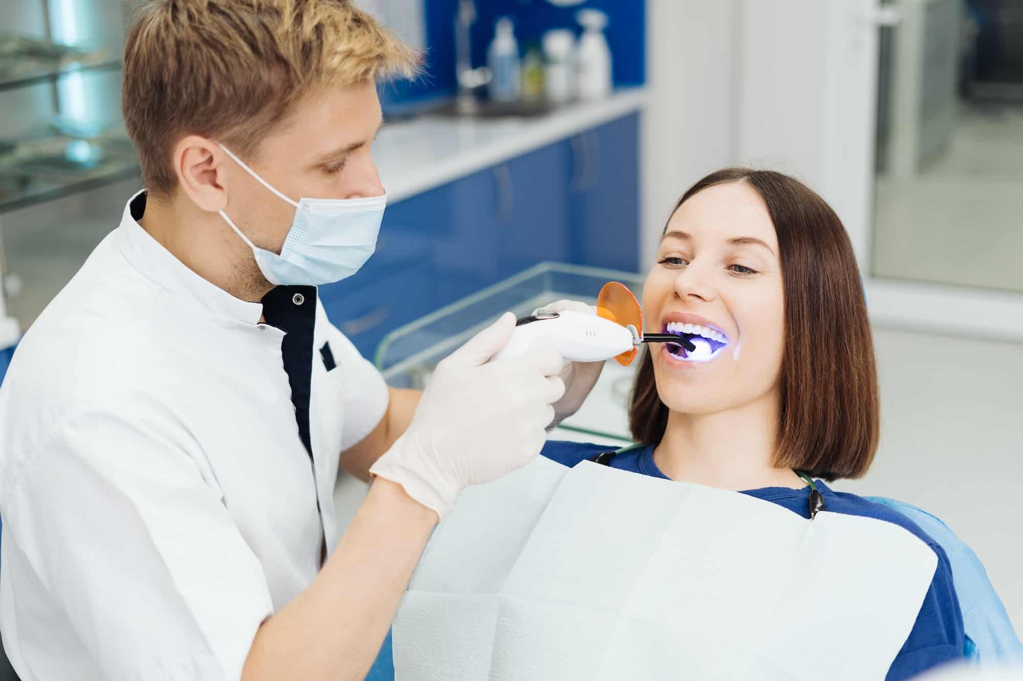 Whitening teeth procedure during visit at dentist.